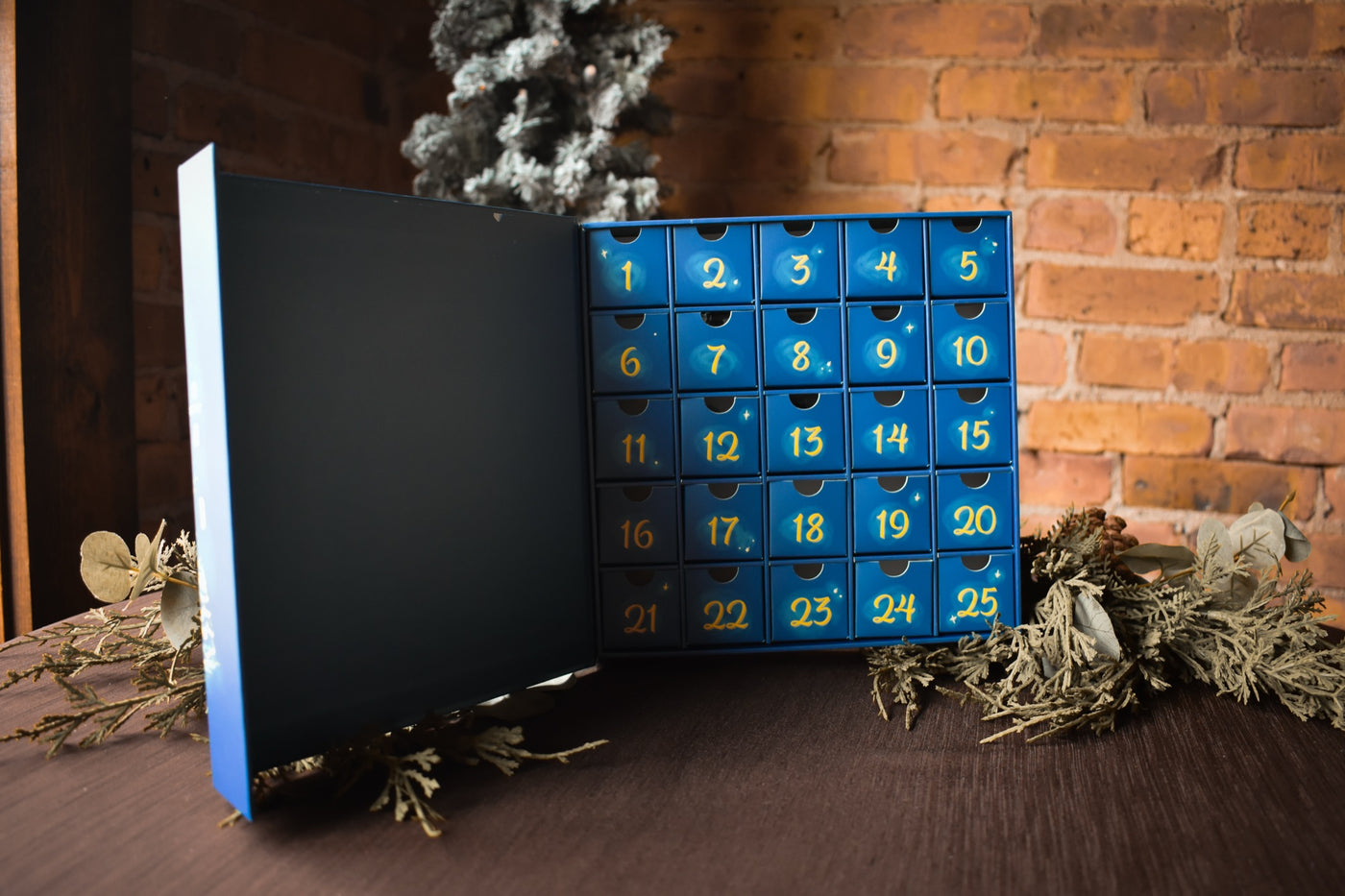 The open Christmas on the Square calendar: twenty-five starry blue drawers with hand-lettered gold numbers