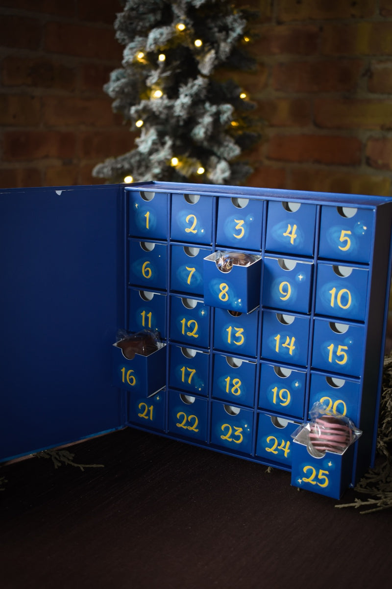 Drawers 8, 16, and 25 pulled open, wrapped chocolates peeking out